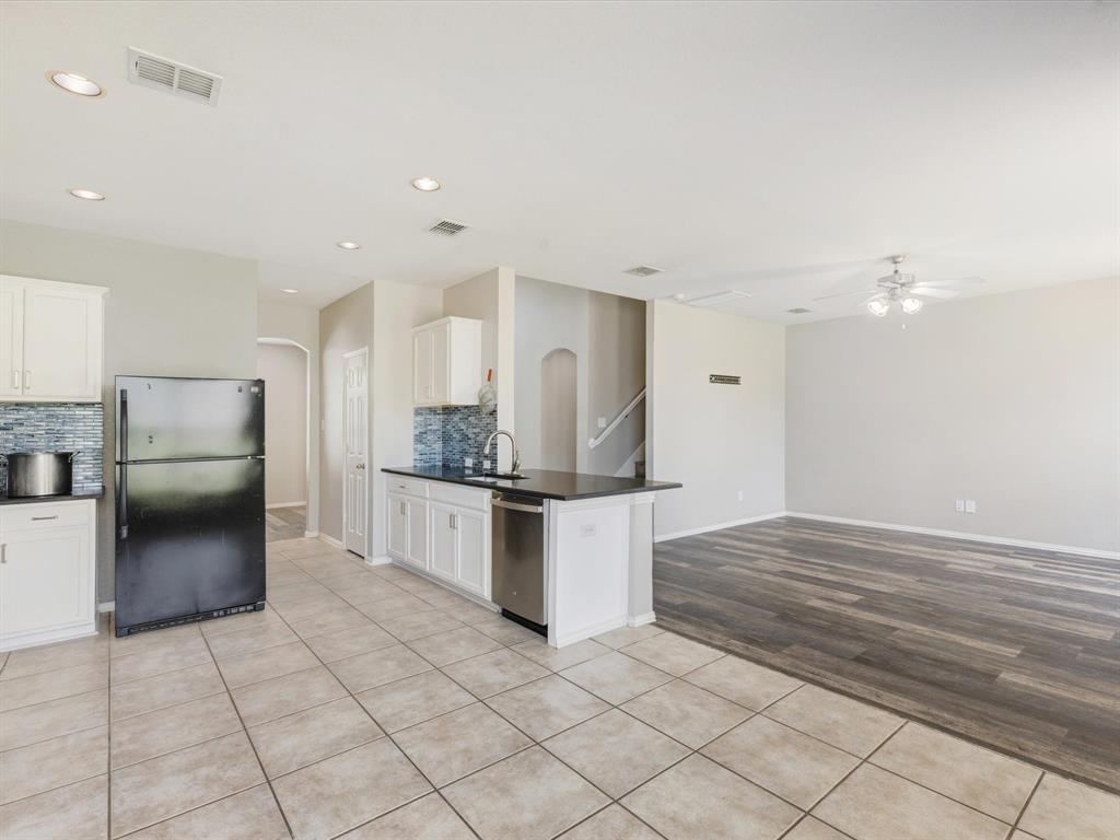 2009 Cooper Ridge Lane Heartland, TX 75126 - Photo 39 of 40 Kitchen featuring light tile patterned floors, freestanding refrigerator, backsplash, ceiling fan, and open floor plan