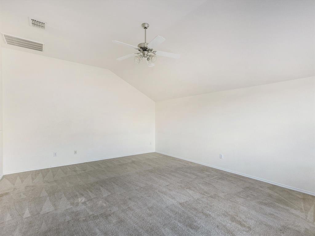 2009 Cooper Ridge Lane Heartland, TX 75126 - Photo 20 of 40 Empty room featuring vaulted ceiling, carpet flooring, and ceiling fan