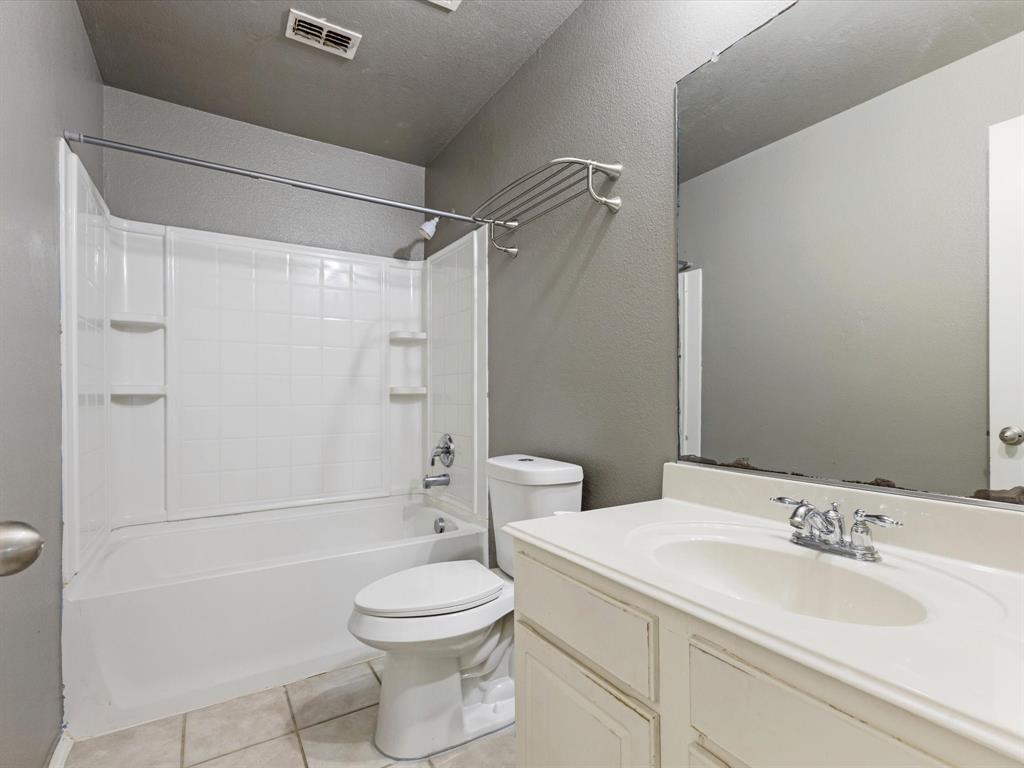 2009 Cooper Ridge Lane Heartland, TX 75126 - Photo 26 of 40 Bathroom featuring shower / bath combination, a textured wall, light tile patterned floors, vanity, and a textured ceiling