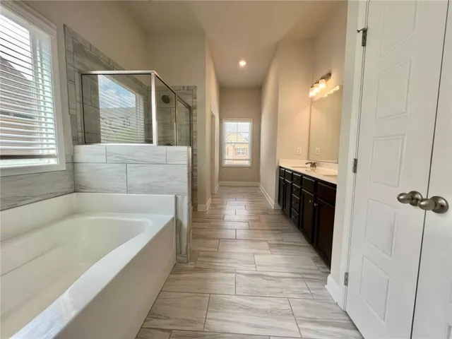 a bathroom with a bathtub and double vanity