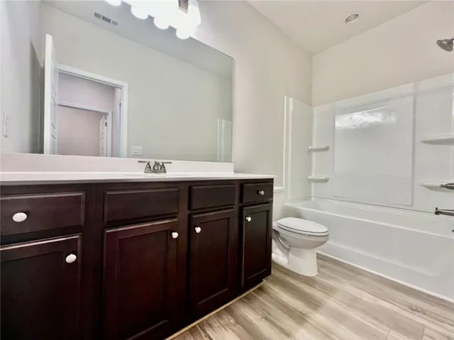 a bathroom with a sink a toilet a mirror and bathtub