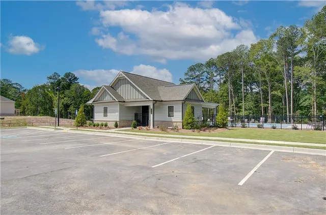 a view of a white house with a big yard and large trees