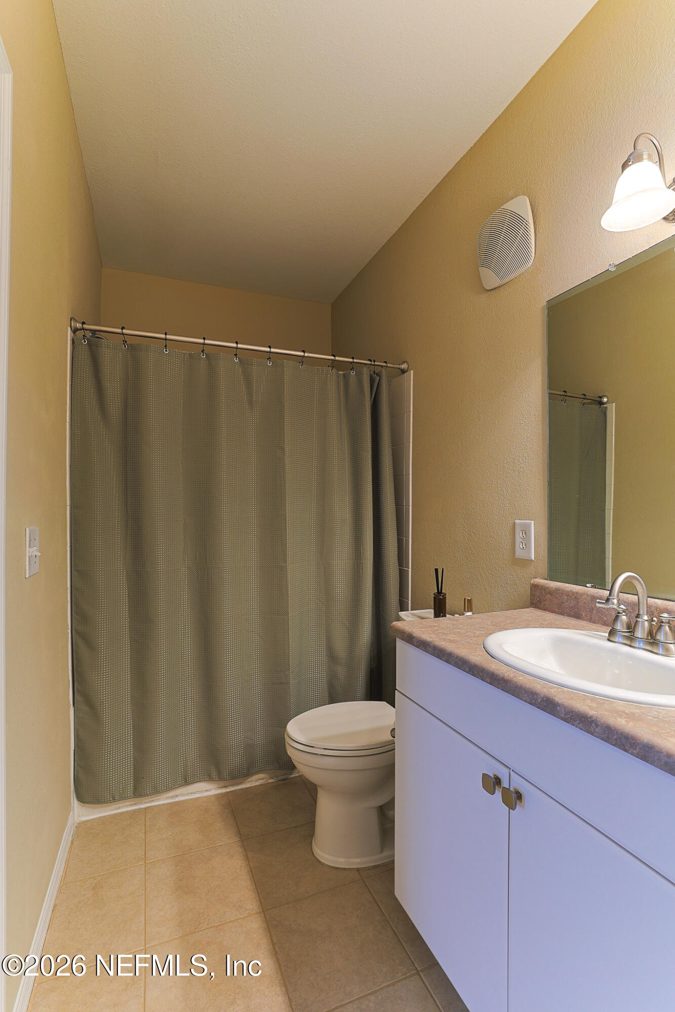 10961 Burnt Mill Road, Unit 426 Jacksonville, FL 32256 - Photo 14 of 24 a bathroom with a sink a toilet a mirror and shower curtain