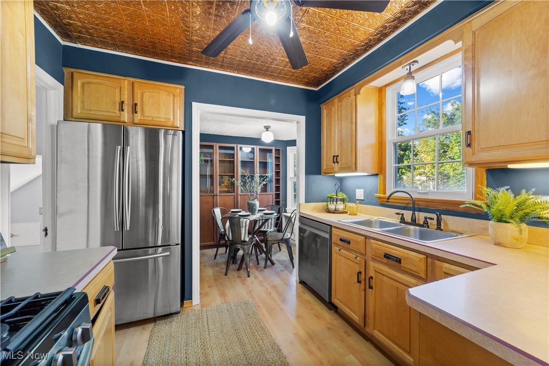 3690 Daleford Road Cleveland, OH 44120 - Photo 12 of 45 Kitchen featuring appliances with stainless steel finishes, light wood-style floors, an ornate ceiling, light countertops, and a ceiling fan
