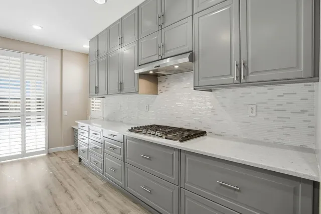 a kitchen with a sink and wooden floor