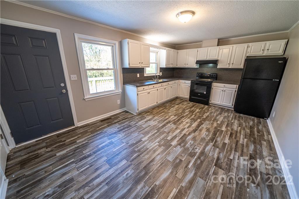 250 Rock Church Road Oakboro, NC 28129 - Photo 11 of 21 a kitchen with granite countertop stainless steel appliances a refrigerator sink and microwave