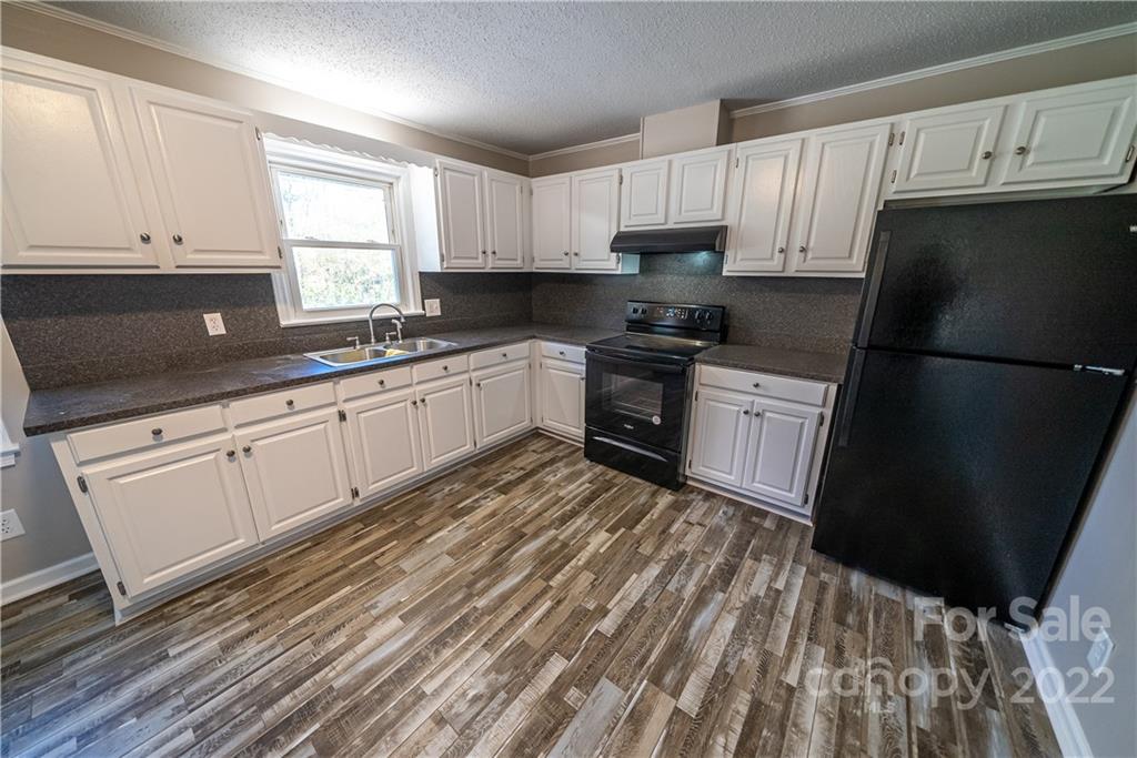 250 Rock Church Road Oakboro, NC 28129 - Photo 12 of 21 a kitchen with granite countertop a refrigerator a sink dishwasher a stove top oven a refrigerator and cabinets
