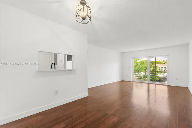 a view of a room with wooden floor and window