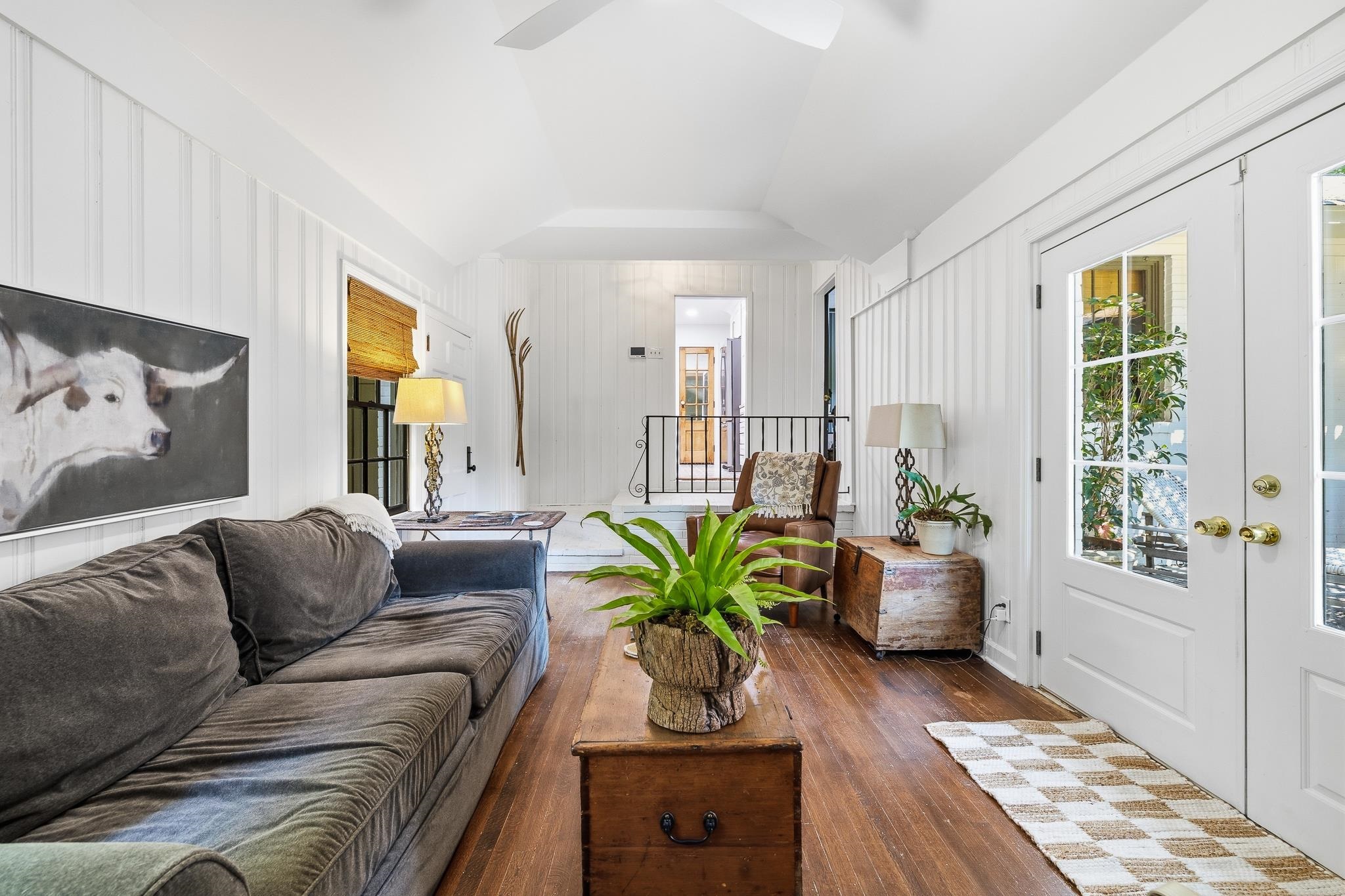253 Ridgefield Road Memphis, TN 38111 - Photo 17 of 32 Living area with wood-finish flooring, white vertical plank wall paneling, and a vaulted ceiling with a ceiling fan
