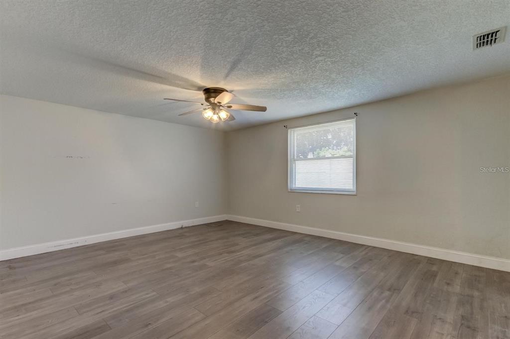 7144 Fairfax Drive Port Richey, FL 34668 - Photo 20 of 53 a view of an empty room with wooden floor and a window