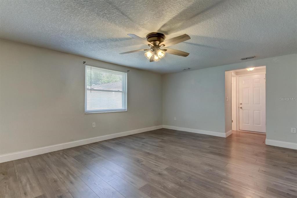 7144 Fairfax Drive Port Richey, FL 34668 - Photo 21 of 53 a view of an empty room with a window and wooden floor