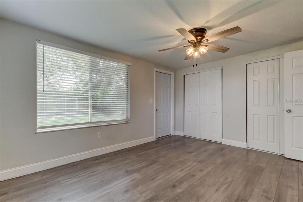 7144 Fairfax Drive Port Richey, FL 34668 - Photo 28 of 53 a view of an empty room with a window and wooden floor