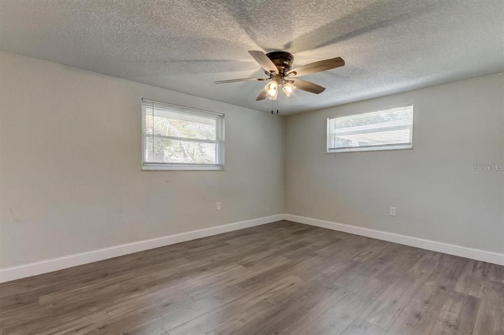 7144 Fairfax Drive Port Richey, FL 34668 - Photo 31 of 53 a view of an empty room with wooden floor and a window