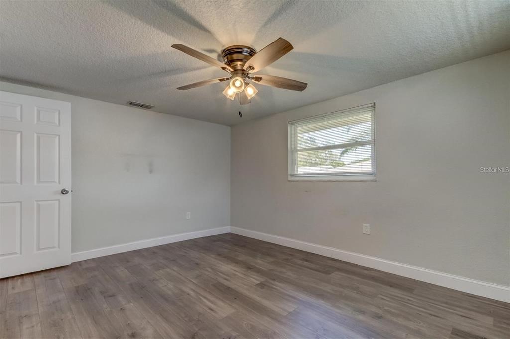 7144 Fairfax Drive Port Richey, FL 34668 - Photo 34 of 53 a view of an empty room with wooden floor and a window