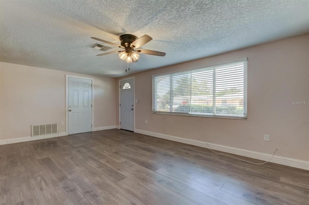 7144 Fairfax Drive Port Richey, FL 34668 - Photo 5 of 53 a view of empty room with wooden floor and fan