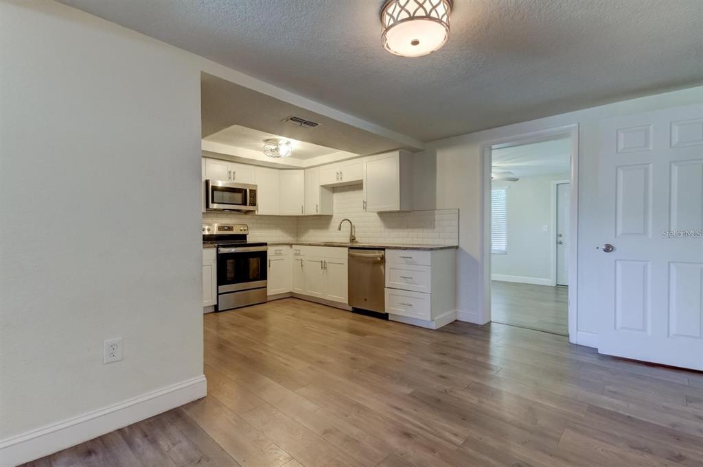 7144 Fairfax Drive Port Richey, FL 34668 - Photo 7 of 53 a view of a kitchen with a sink cabinets and wooden floor