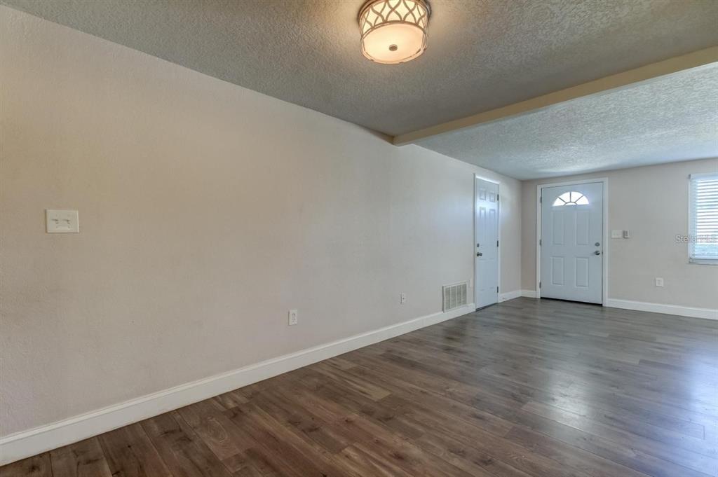 7144 Fairfax Drive Port Richey, FL 34668 - Photo 9 of 53 an empty room with wooden floor and windows
