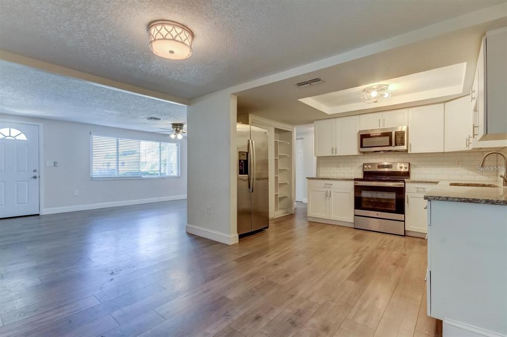 7144 Fairfax Drive Port Richey, FL 34668 - Photo 10 of 53 a kitchen with stainless steel appliances granite countertop a refrigerator and a stove top oven