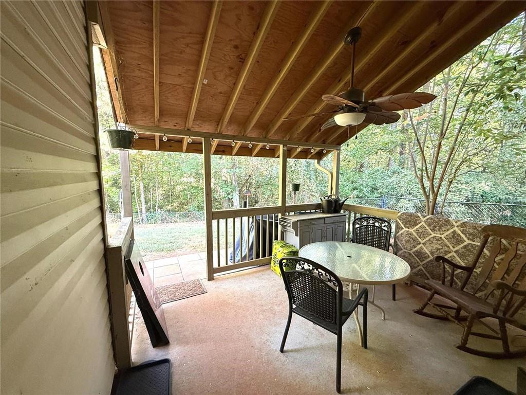 1071 Covenant Court Bethlehem, GA 30620 - Photo 12 of 20 a view of a patio with table and chairs and floor to ceiling window with wooden floor
