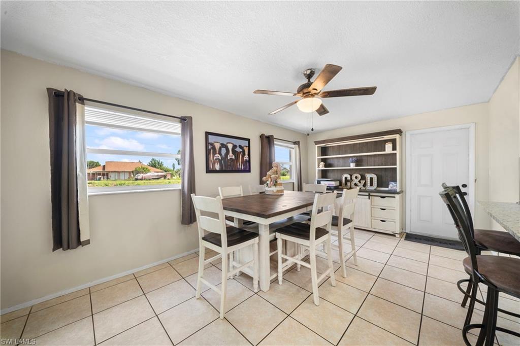 7289 Barragan Road Fort Myers, FL 33967 - Photo 8 of 18 Dining space featuring ceramic tile flooring, a ceiling fan with integrated lighting, and built-in shelving with lower cabinetry