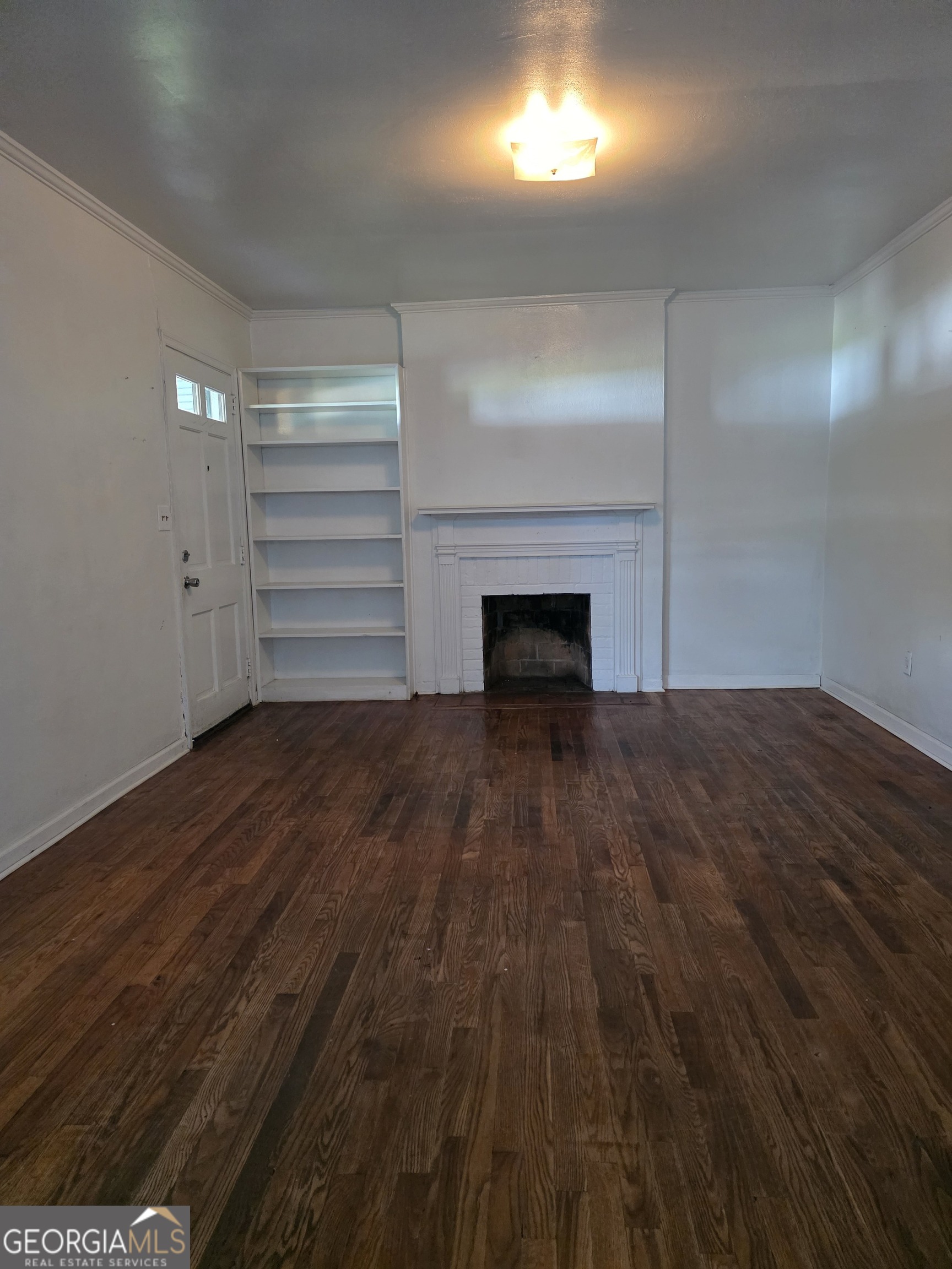 419 Chamlee Drive Fort Valley, GA 31030 - Photo 2 of 10 a view of empty room with wooden floor fireplace and windows