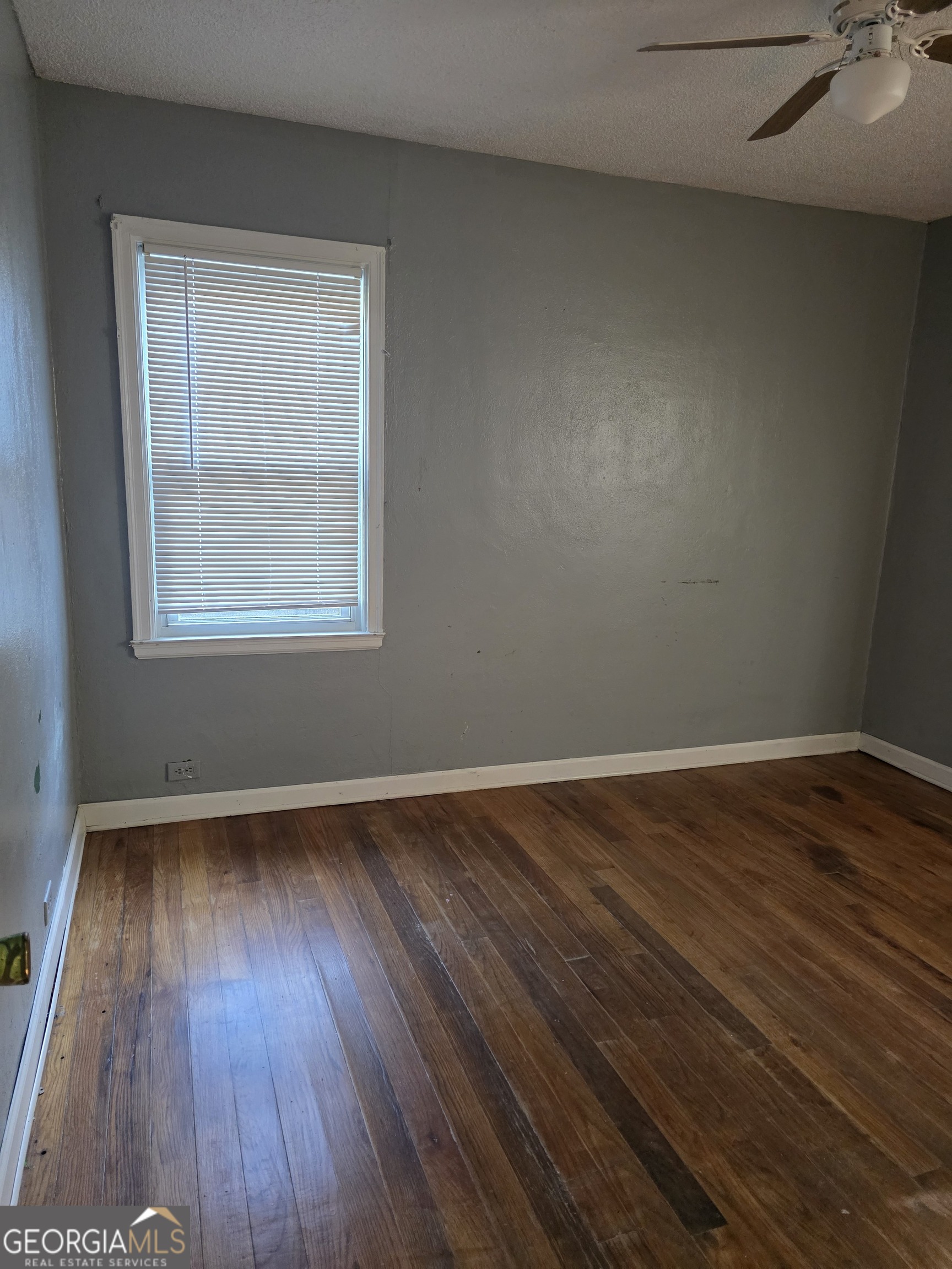 419 Chamlee Drive Fort Valley, GA 31030 - Photo 8 of 10 a view of an empty room with wooden floor and a window
