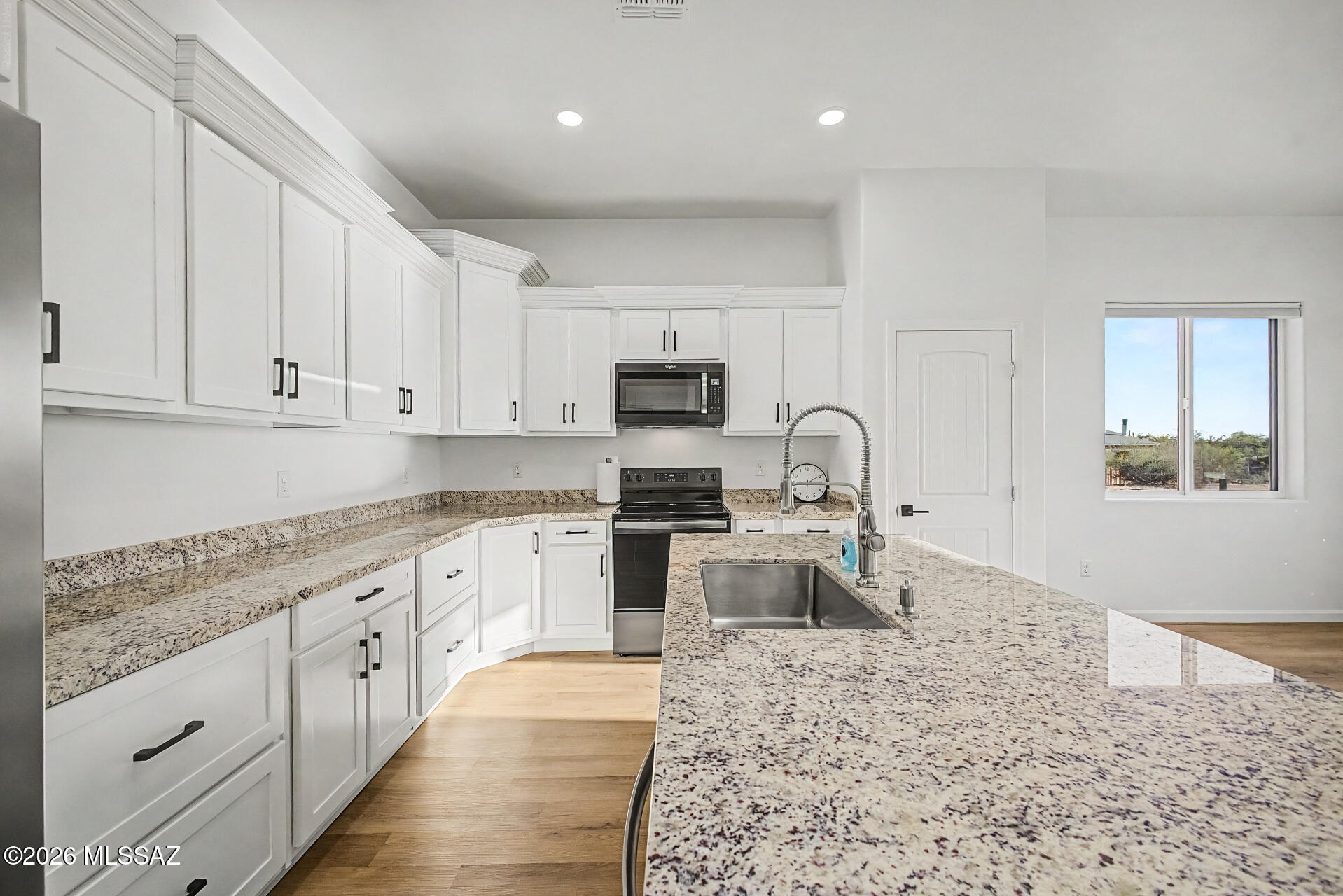 4601 East Magoo Road Tucson, AZ 85739 - Photo 5 of 38 a kitchen with granite countertop white cabinets and stainless steel appliances