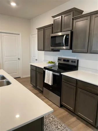 a kitchen with stainless steel appliances a sink a stove a microwave and cabinets
