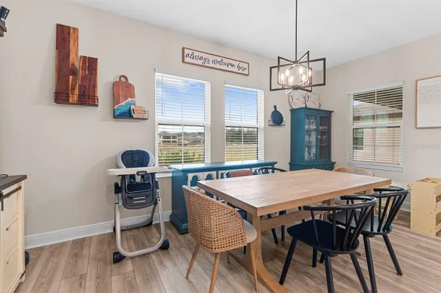 a view of a dining room with furniture a chandelier and wooden floor