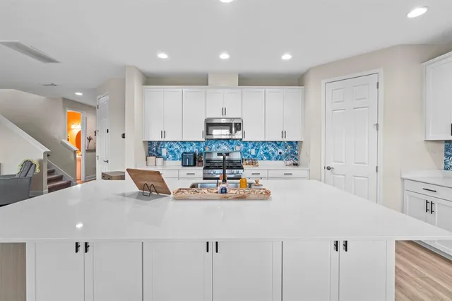 a kitchen with a sink a stove cabinets and counter space