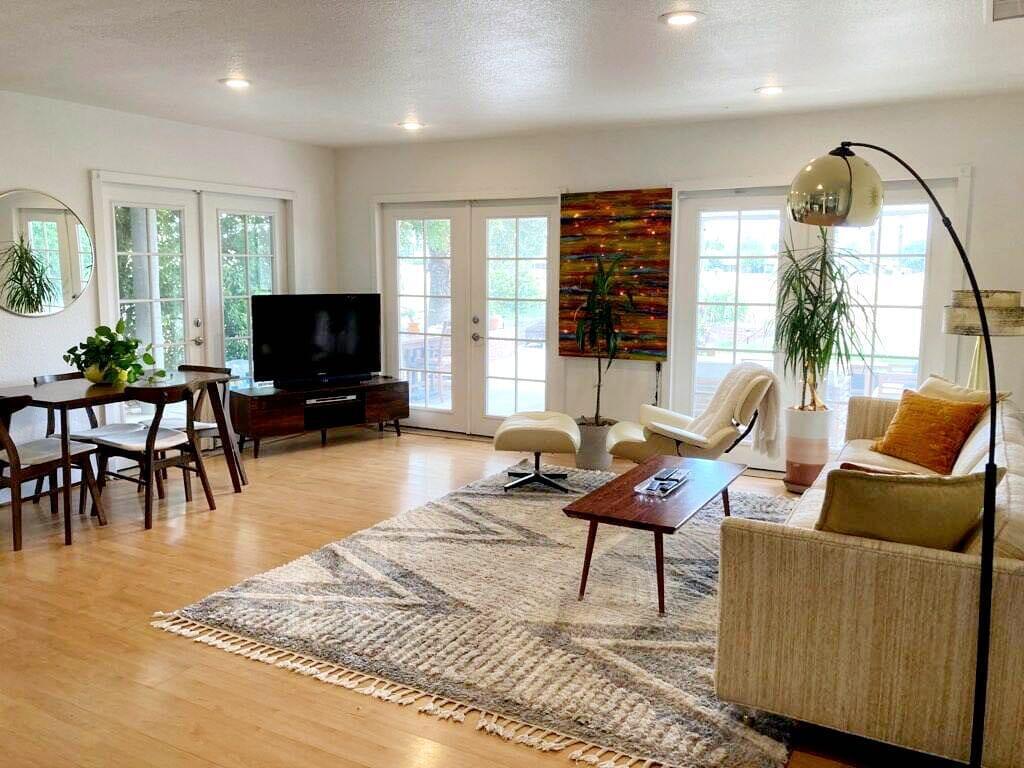 a living room with furniture and a flat screen tv with wooden floor