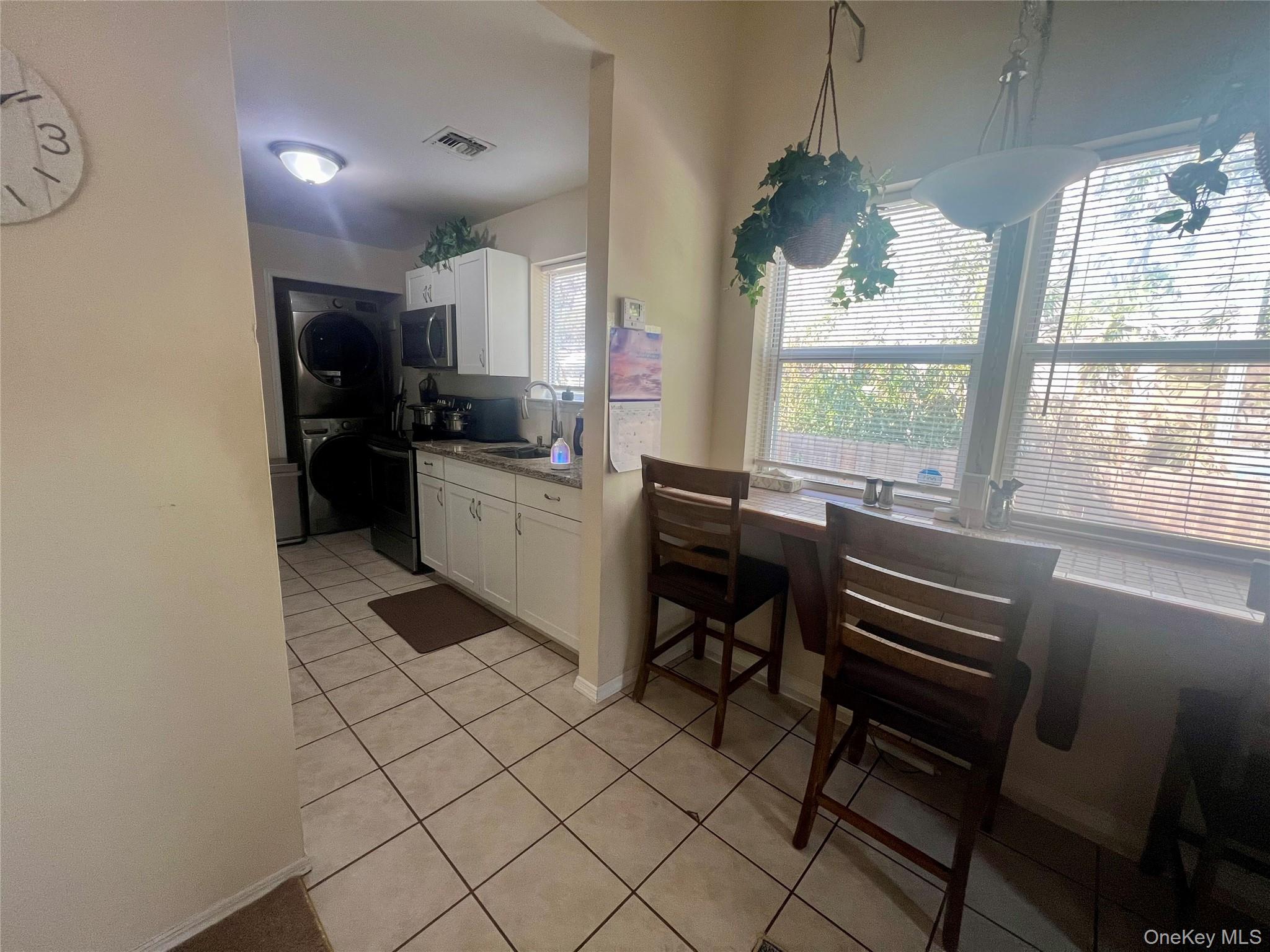 10 Rutland Road Mastic, NY 11950 - Photo 5 of 12 a kitchen with a sink dining table and chairs
