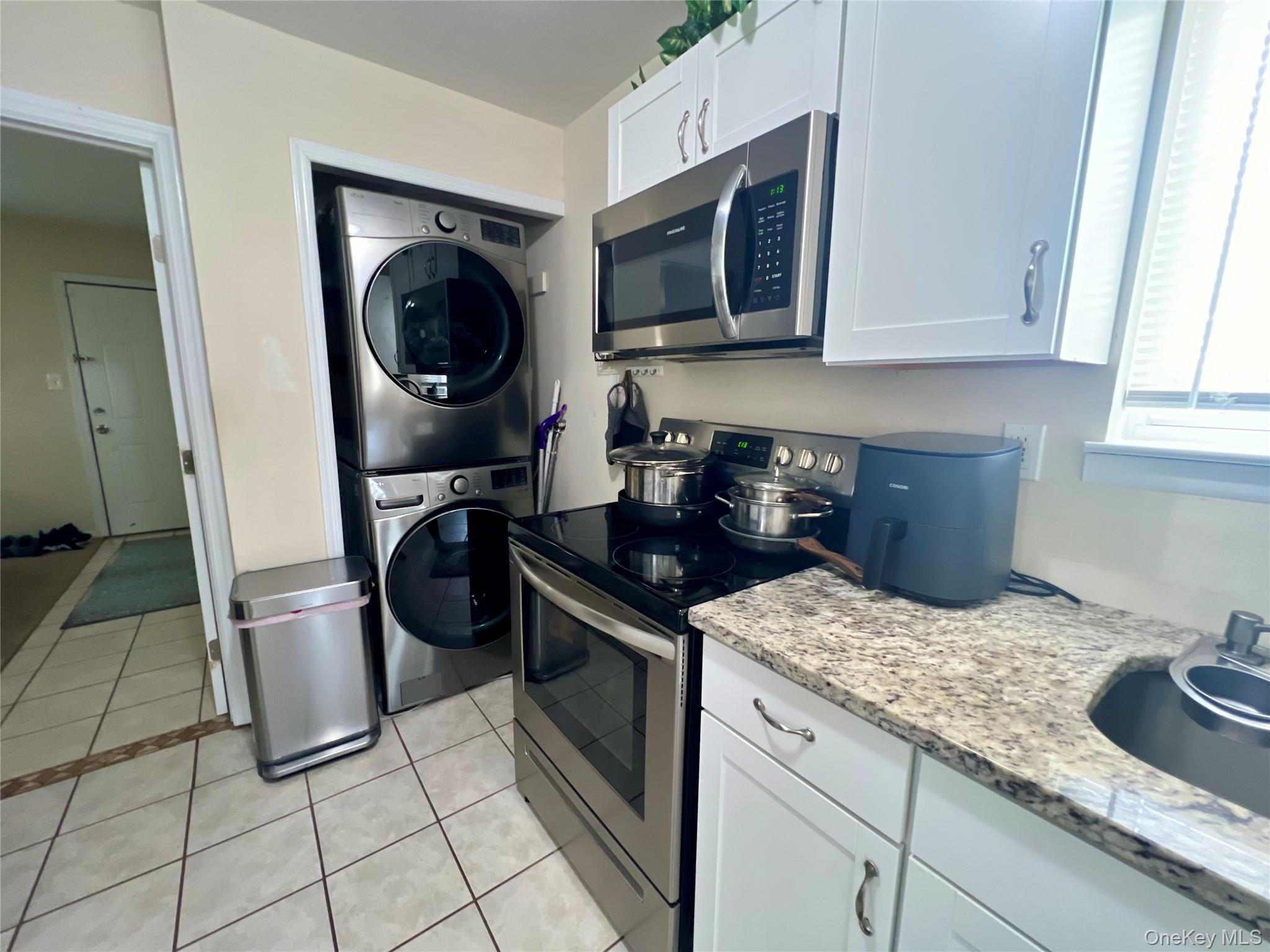 10 Rutland Road Mastic, NY 11950 - Photo 10 of 12 a kitchen with a stove a sink and a cabinets