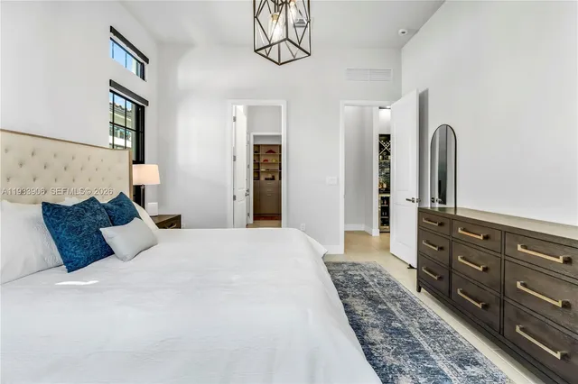 a bedroom with a bed and dresser with mirror