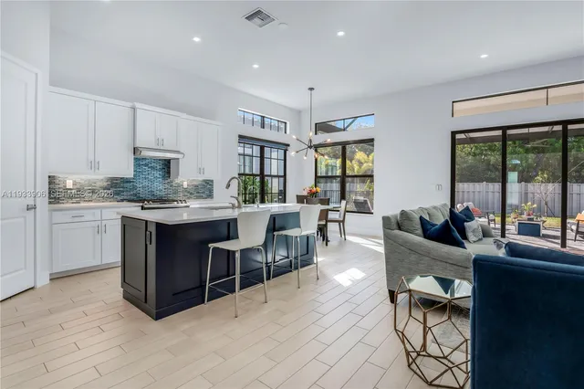 a living room with stainless steel appliances granite countertop furniture a couch a large window and kitchen view