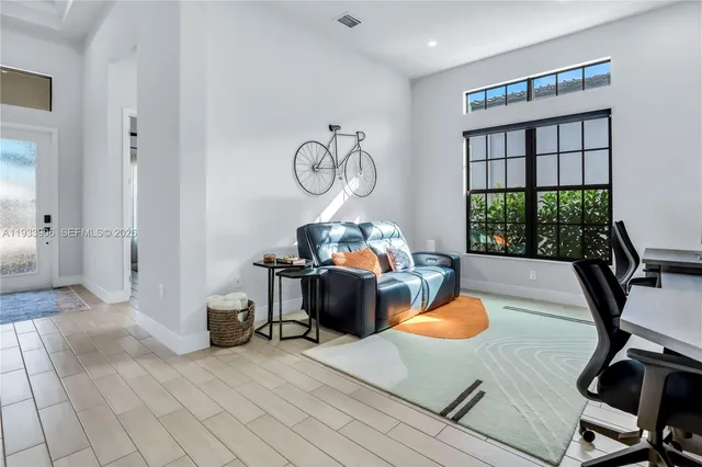 a living room with furniture a window and gym equipment