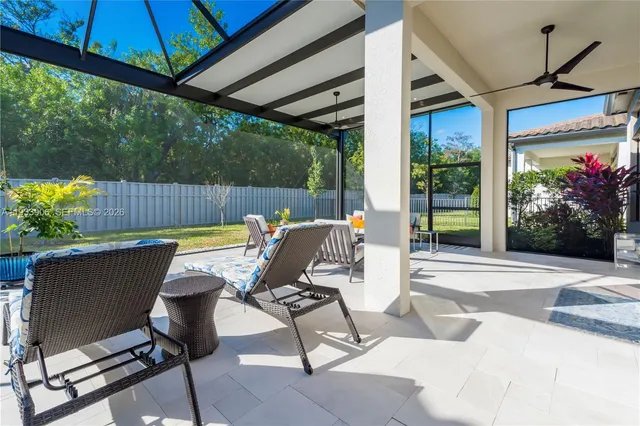 a view of a patio with table and chairs potted plants with wooden floor and fence