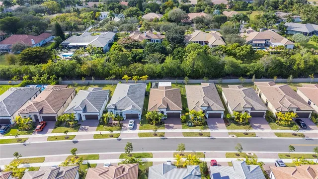 an aerial view of residential house with swimming pool and large trees