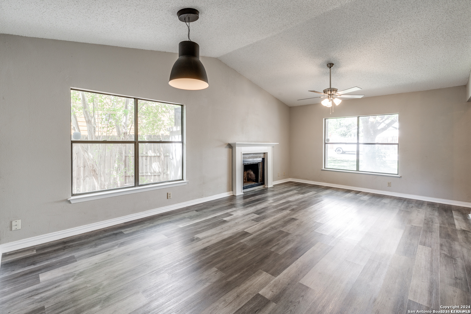 9727 Fortune Ridge Drive Converse, TX 78109 - Photo 4 of 14 an empty room with wooden floor chandelier and windows