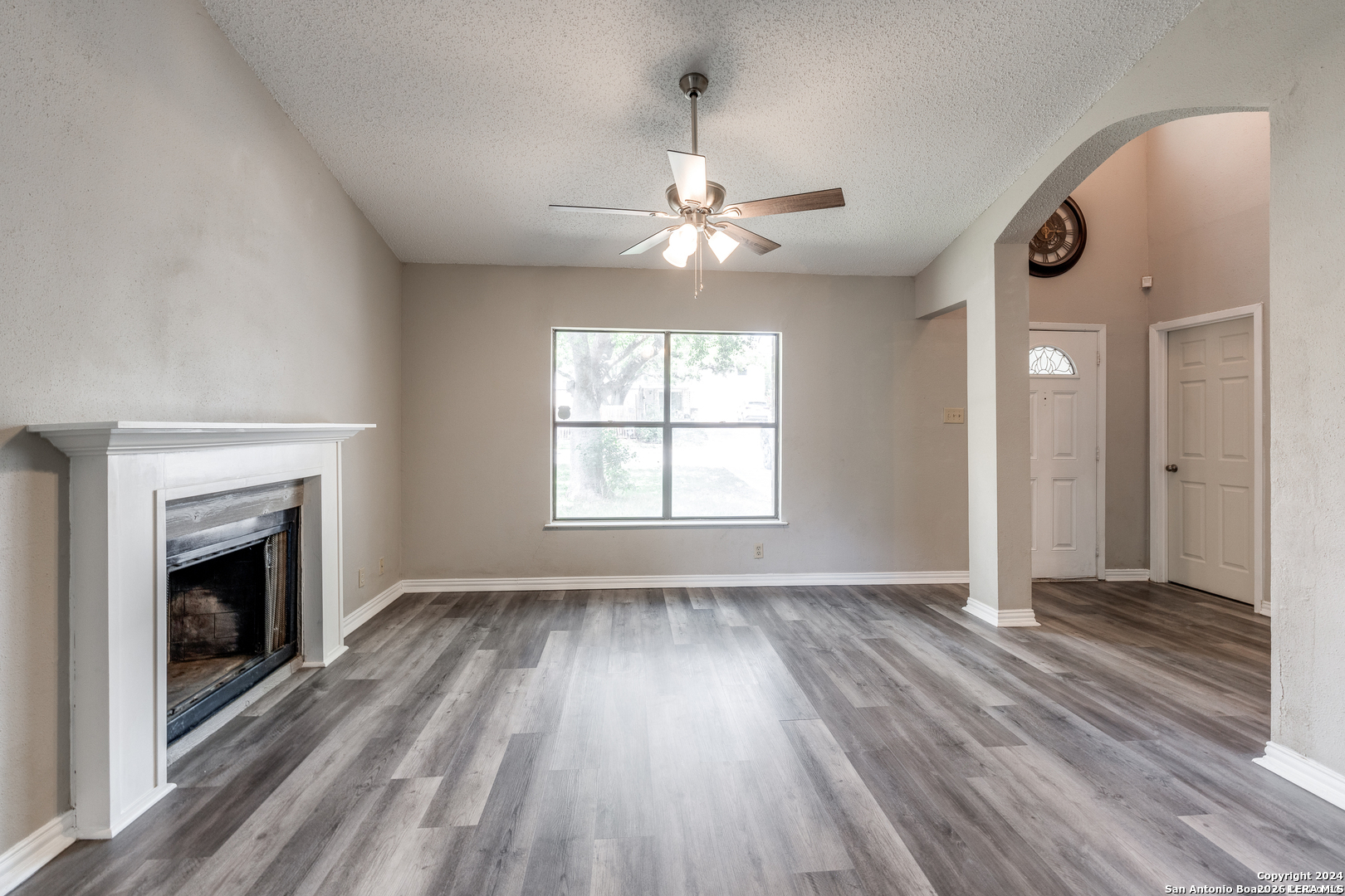 9727 Fortune Ridge Drive Converse, TX 78109 - Photo 5 of 14 an empty room with wooden floor fireplace and windows