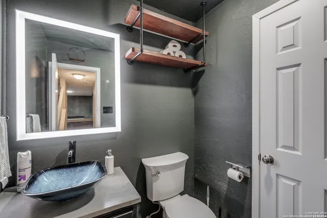 a bathroom with a sink toilet and mirror