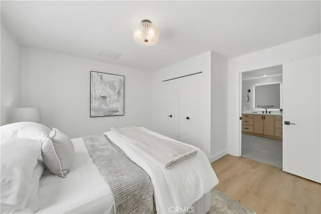 a bedroom with a bed and a lamp on the dresser