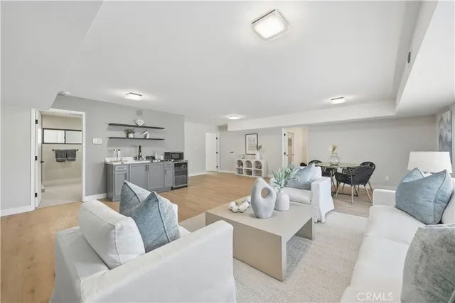a living room with furniture white walls and kitchen view