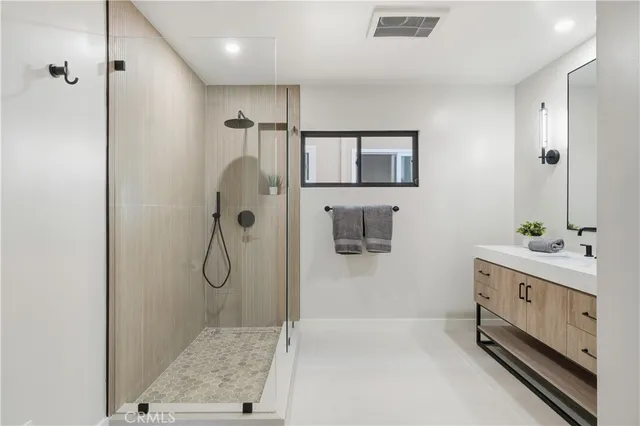 a bathroom with a double vanity sink mirror and shower