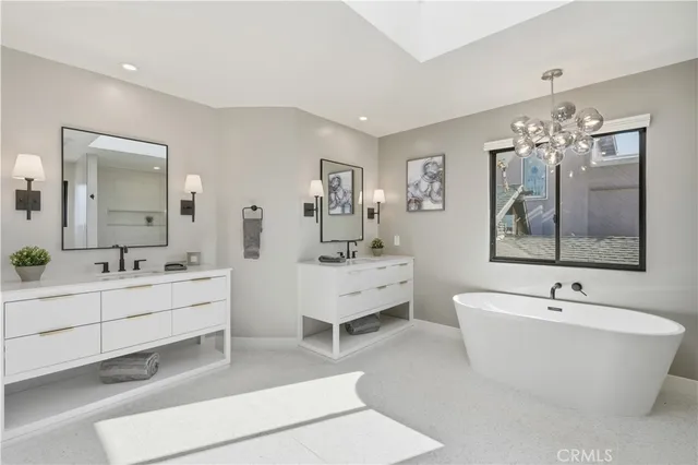 a spacious bathroom with double vanity sinks a large mirror and a bathtub