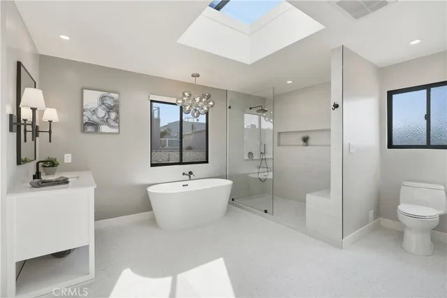 a spacious bathroom with a bathtub sink mirror and toilet
