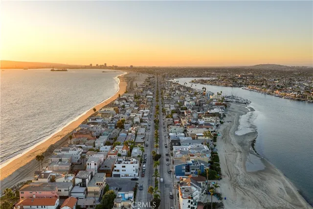 an aerial view of ocean and residential houses with outdoor space