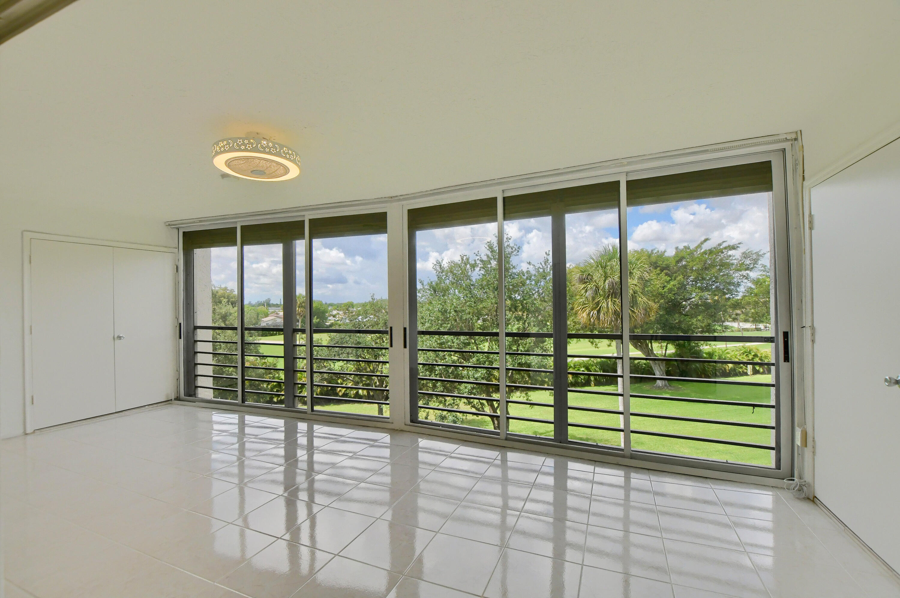 9170 Southwest 14th Street, Unit 4405 Boca Raton, FL 33428 - Photo 10 of 48 a view of an empty room with wooden floor and a window