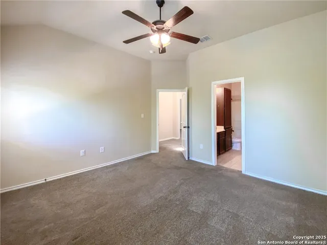 an empty room with closet and a ceiling fan