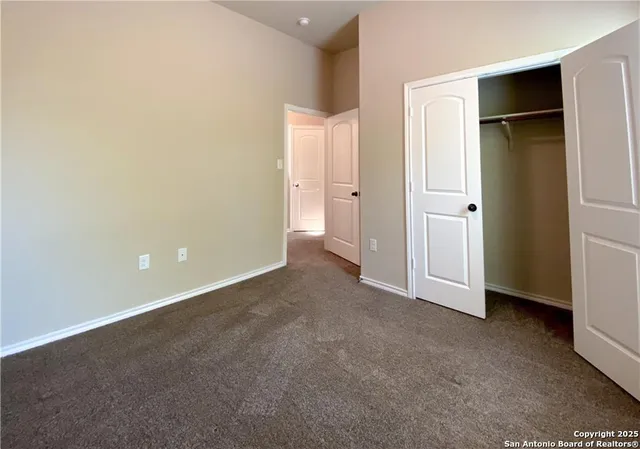 an empty room with closet and wooden door